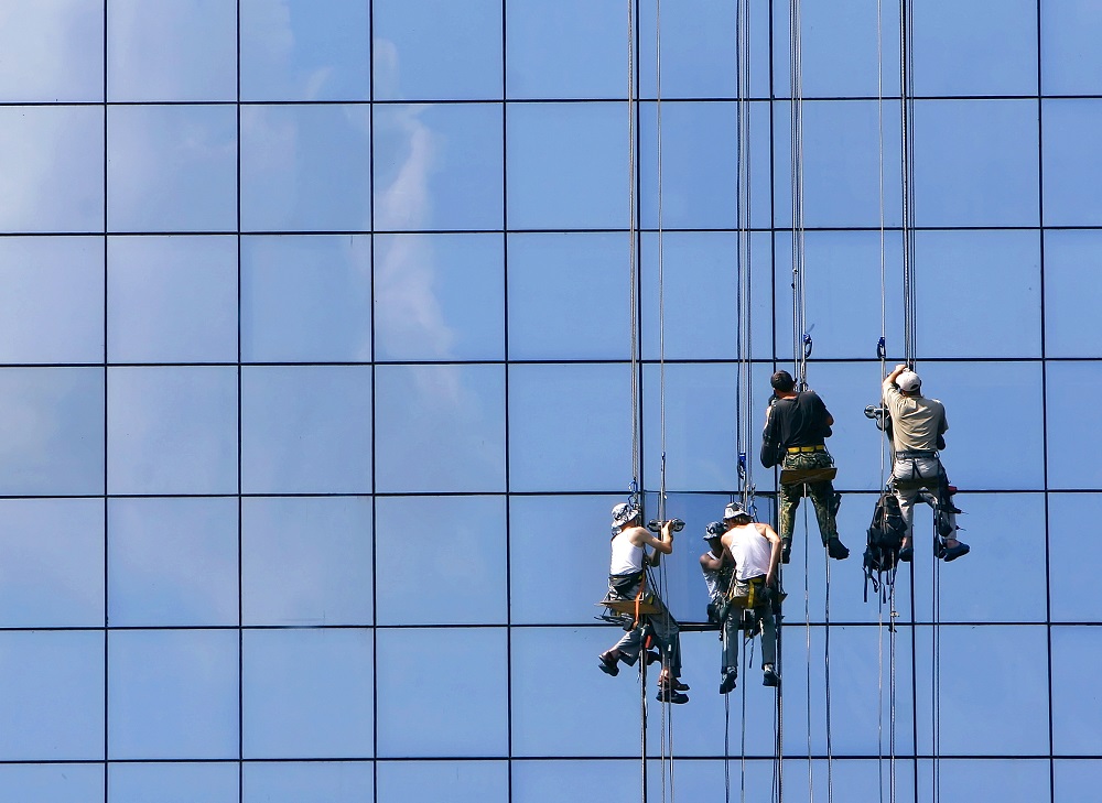 window washers on glass building facade window washers on glass building facade